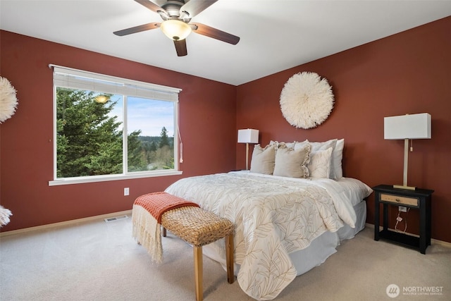 bedroom featuring a ceiling fan, light colored carpet, visible vents, and baseboards