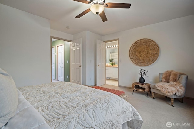 carpeted bedroom with ceiling fan and ensuite bath