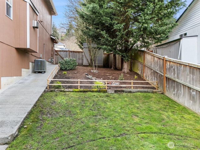 view of yard featuring a garden, a fenced backyard, and central AC unit