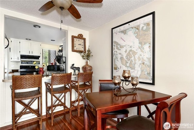 dining room featuring a textured ceiling, a ceiling fan, and wood finished floors