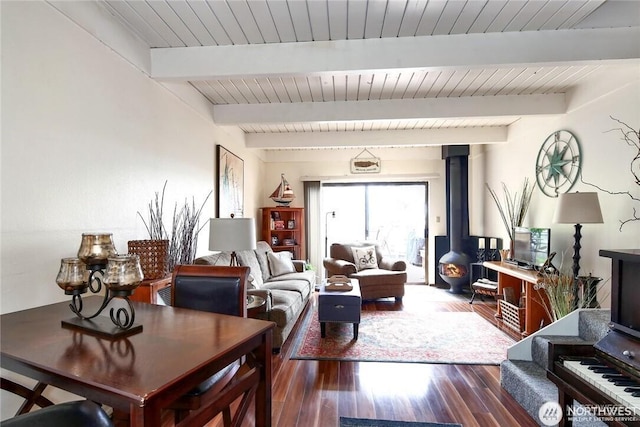 living room featuring beamed ceiling, dark wood-type flooring, wooden ceiling, and a wood stove