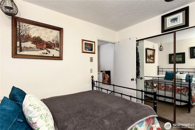 bedroom featuring a textured ceiling and carpet