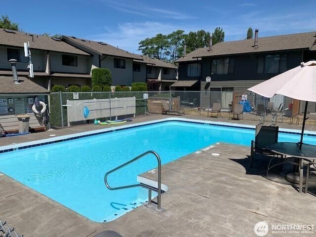 community pool featuring a patio and fence