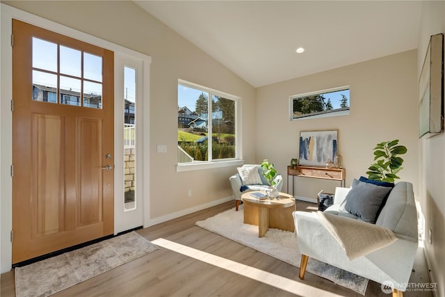 foyer with lofted ceiling, light wood-style floors, baseboards, and recessed lighting