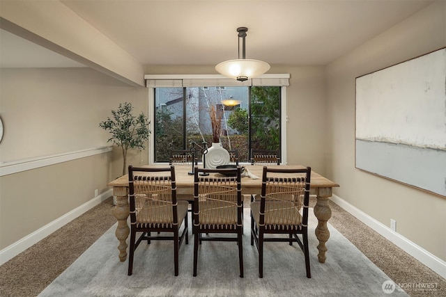 dining space featuring baseboards and carpet flooring