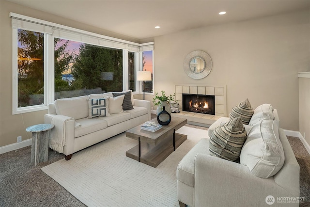 living room featuring a tiled fireplace, recessed lighting, baseboards, and carpet floors