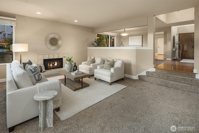 carpeted living area with recessed lighting, a tile fireplace, and baseboards