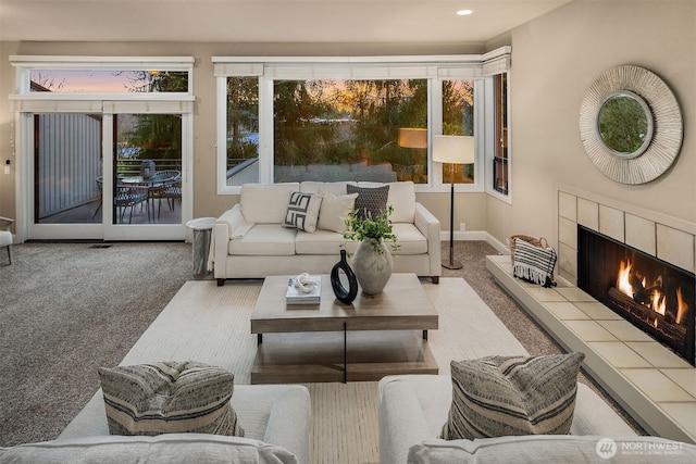 carpeted living room featuring a tiled fireplace, recessed lighting, and baseboards