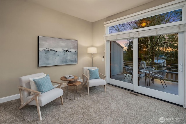 living area featuring visible vents, baseboards, and carpet floors