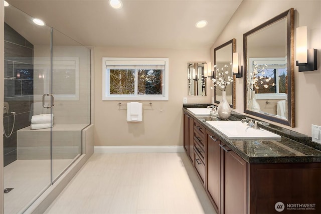 full bathroom featuring a stall shower, a sink, recessed lighting, double vanity, and vaulted ceiling