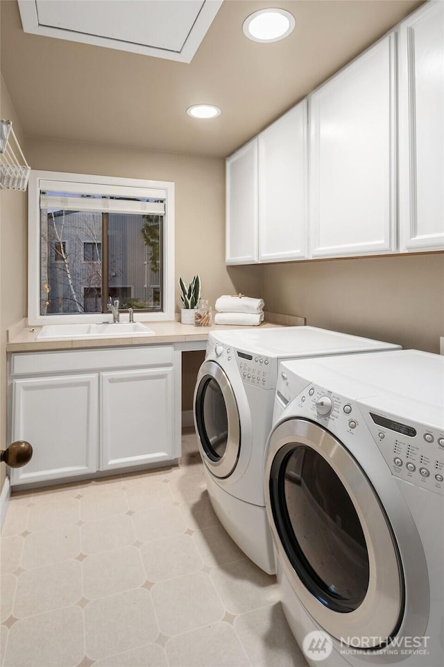 clothes washing area featuring washer and dryer, recessed lighting, cabinet space, and a sink