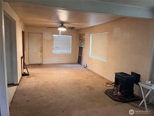 12535 SE Kent Kangley Rd, Kent, WA 98030 - unfurnished living room with a wood stove, a ceiling fan, and light colored carpet