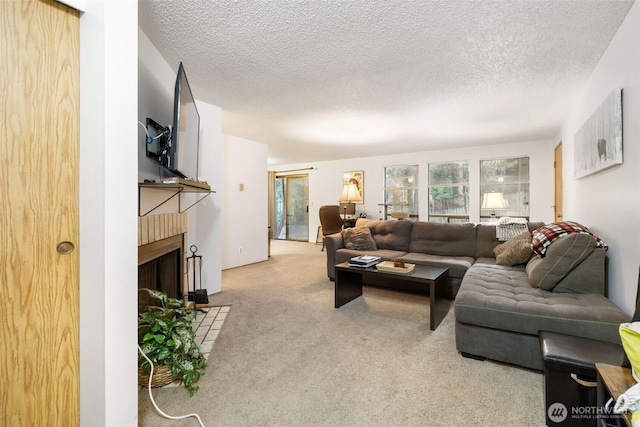 carpeted living area featuring a fireplace and a textured ceiling