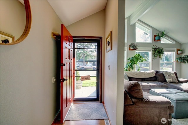 entryway with lofted ceiling with beams and baseboards