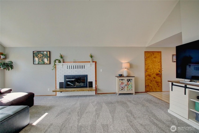 living room with baseboards, carpet floors, a brick fireplace, and vaulted ceiling