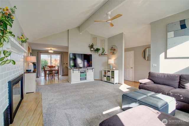 living room with high vaulted ceiling, beam ceiling, a fireplace, ceiling fan, and light colored carpet