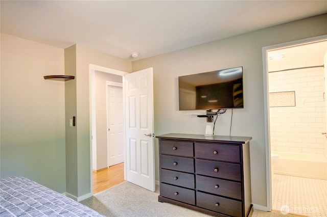 bedroom featuring light colored carpet, connected bathroom, and baseboards