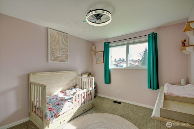 bedroom featuring a nursery area, baseboards, carpet, and visible vents