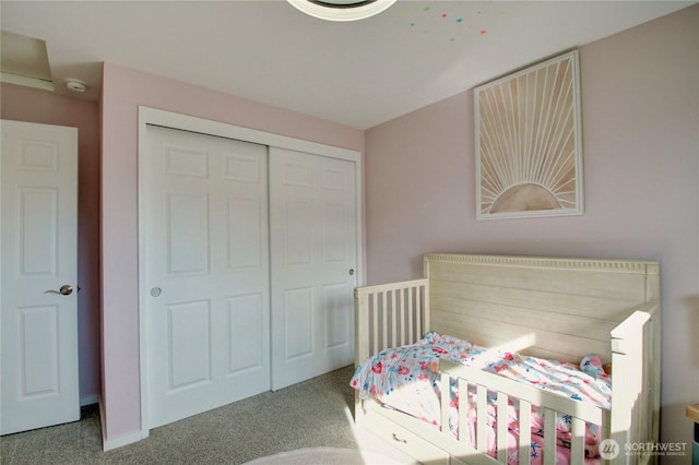 carpeted bedroom with a closet and baseboards