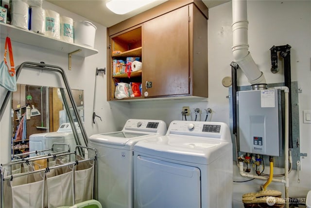 clothes washing area with water heater, cabinet space, and independent washer and dryer