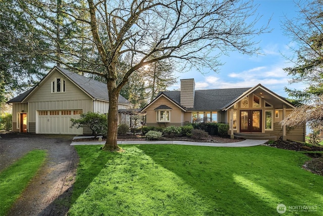 view of front of house with board and batten siding, a front yard, french doors, and gravel driveway