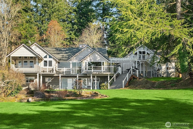 rear view of house featuring a pergola, a lawn, a deck, and stairs