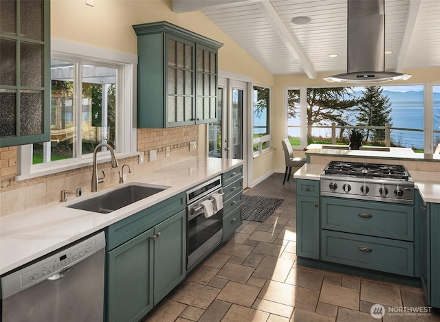 kitchen featuring green cabinets, appliances with stainless steel finishes, and wall chimney range hood