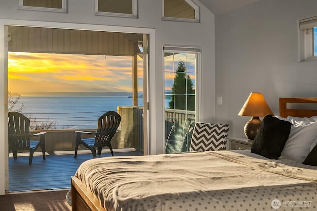 bedroom with vaulted ceiling, a water view, wood finished floors, and access to exterior