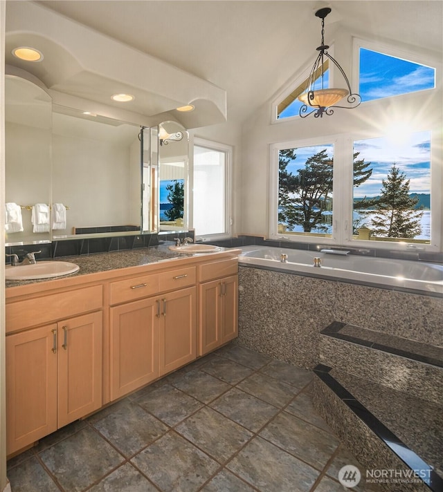 interior space featuring pendant lighting, vaulted ceiling, a sink, and tile countertops