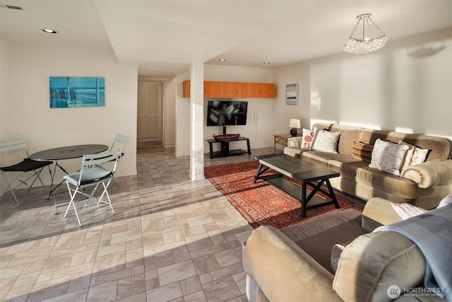 living area featuring recessed lighting, visible vents, and an inviting chandelier