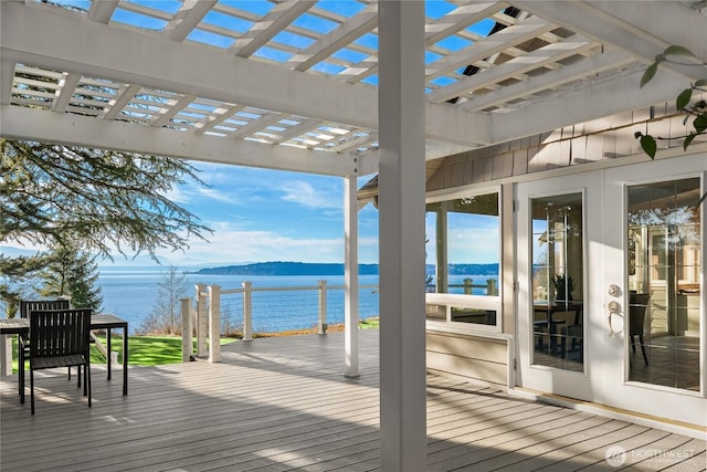 wooden deck with a water view and a pergola