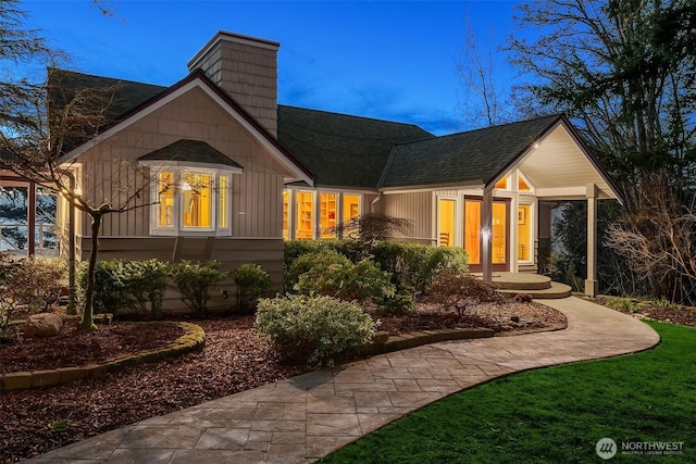 view of front facade with roof with shingles, french doors, and board and batten siding