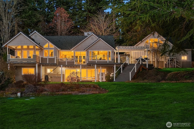 back of property featuring a deck, a yard, stairway, and a pergola