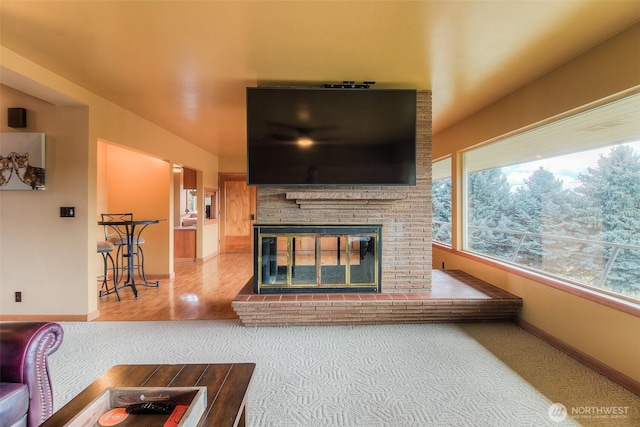 living area with a brick fireplace and baseboards