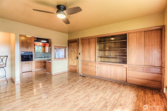 unfurnished living room with light wood-style floors, ceiling fan, and baseboards