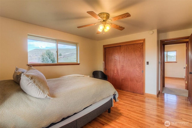 bedroom featuring a closet, a ceiling fan, and light wood-style floors