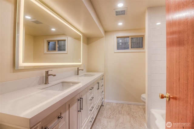 full bathroom with toilet, marble finish floor, visible vents, and a sink