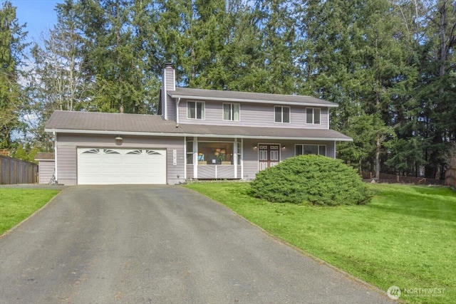 view of front of property with a chimney, covered porch, a garage, driveway, and a front lawn