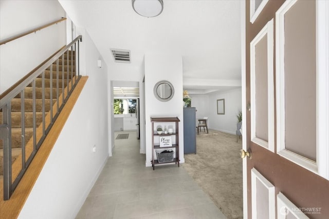 hall featuring stairs, visible vents, and baseboards