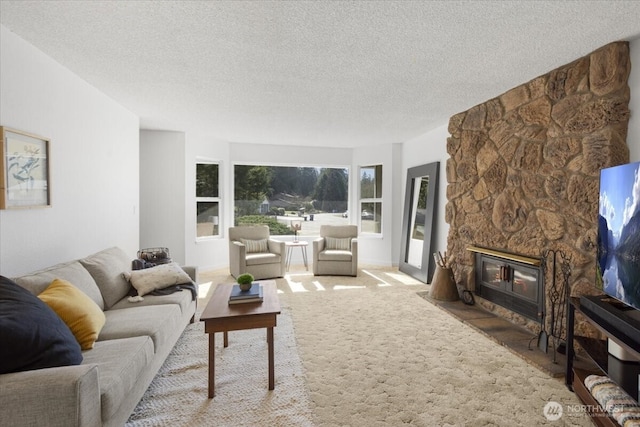 carpeted living area featuring a fireplace and a textured ceiling