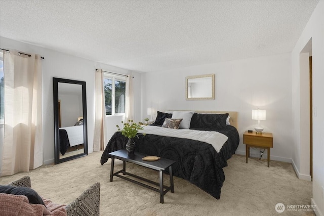 bedroom with light carpet, a textured ceiling, and baseboards