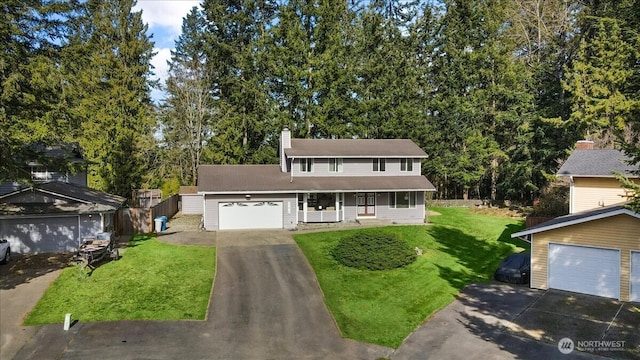 view of front of house with a garage, a chimney, a porch, and a front yard