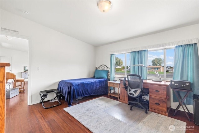 bedroom featuring dark wood finished floors, visible vents, and baseboards