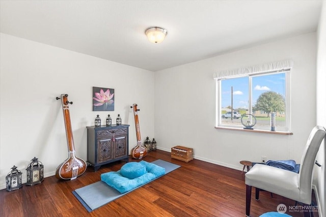 workout room featuring baseboards and wood finished floors