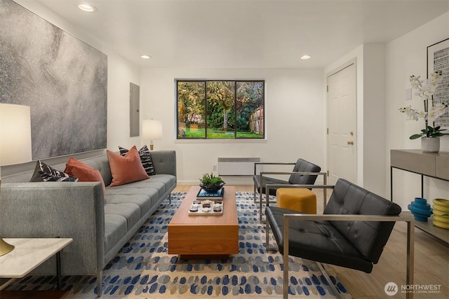 living area featuring radiator, wood finished floors, and recessed lighting