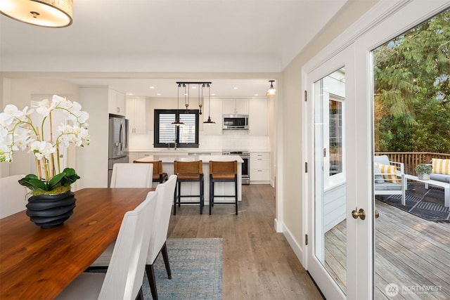 dining space with recessed lighting, french doors, and wood finished floors