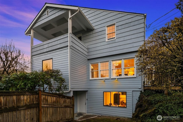 back of property with a sunroom and fence