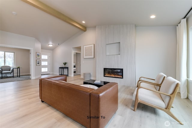 living area with a large fireplace, baseboards, light wood-style flooring, and lofted ceiling with beams