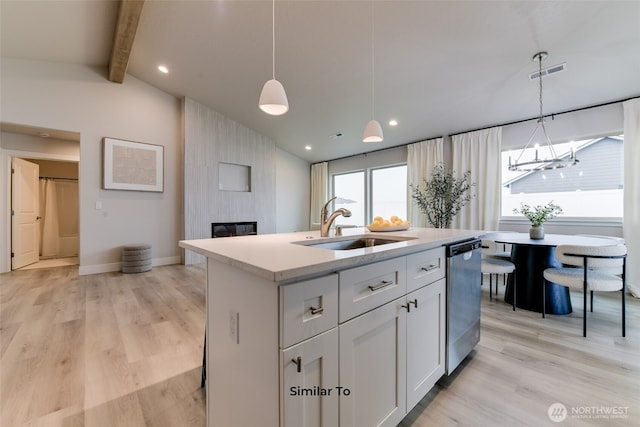 kitchen with visible vents, dishwasher, vaulted ceiling with beams, a fireplace, and a sink