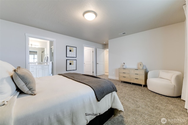 bedroom featuring ensuite bathroom, carpet, visible vents, and baseboards